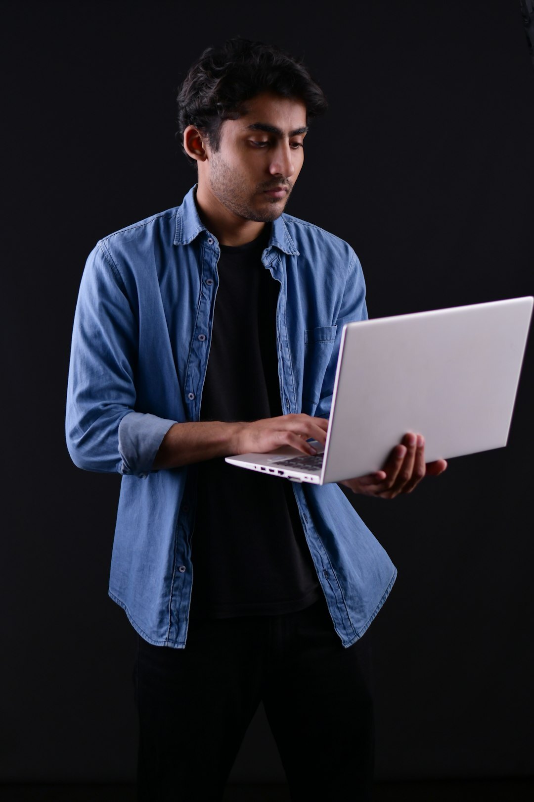 Young man building a mobile app on a laptop